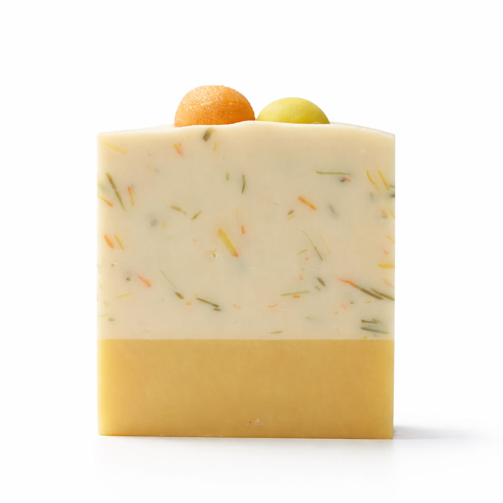 Bar of soap with yellow section on the bottom part and speckled section on the top half with yellow and orange ball shaped embedded on the top on a white background