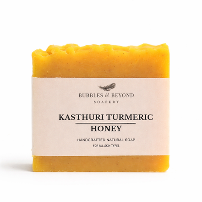 Bar of soap with 'Kasturi turmeric -Honey Bubbles & Beyond' label on a white background